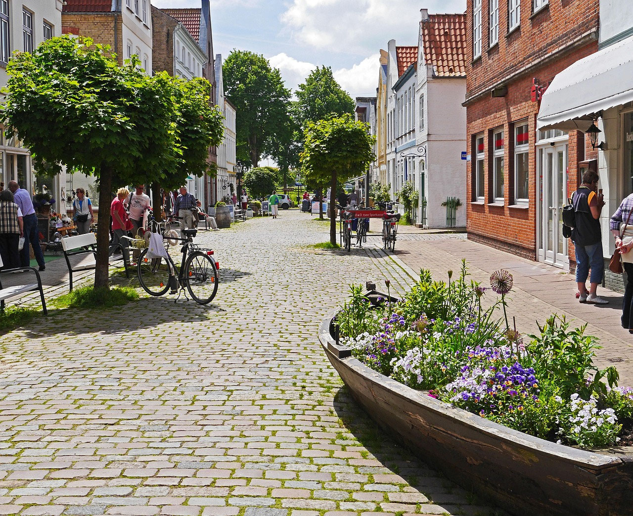 Gasse mit Blumen und Backsteinhäusern